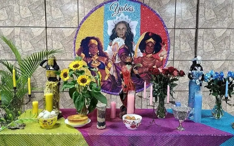 O altar das Yabás no Templo, com girassóis, rosas, velas e imagens